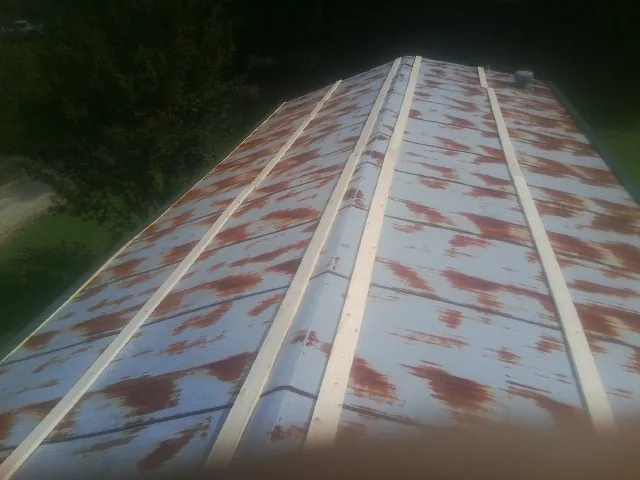 Rusted metal roof panels with new wood purlins before replacement — Storm Damage Roof Repair in Waseca by Roofing Brothers