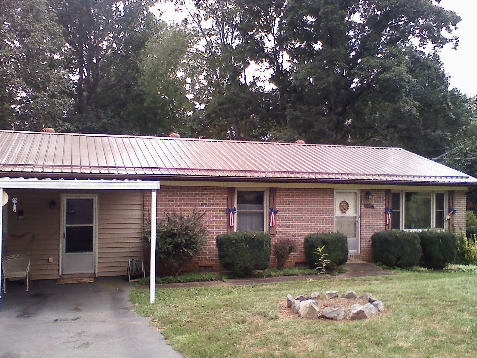 Bronze metal roof and carport on a brick ranch home — Roof Repair work by our crew in Waseca